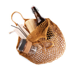Fishnet bag with different items isolated on white, top view. Conscious consumption