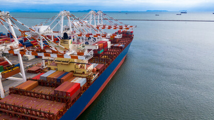 Container ship in export and import business and logistics. Shipping cargo to harbor by crane.