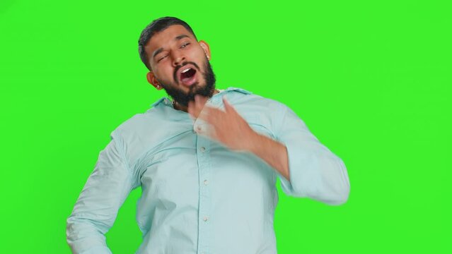 Tired exhausted Indian young man yawning, sleepy inattentive feeling somnolent lazy bored gaping suffering from lack of sleep, falling asleep. Arabian guy isolated on green chroma key background