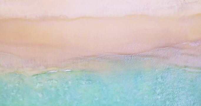 Aerial view of sea crashing waves White foaming waves on beach sand,Top view beach sea surface texture background,Amazing colorful beach sea wonderful sand background