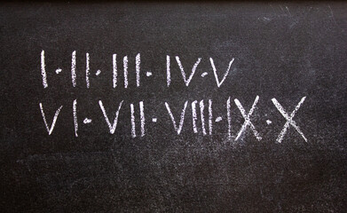 Roman numerals inscription in chalk on a blackboard. Roman numerals from 1 to 10, I to X, learning,...