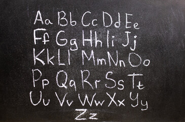 English alphabet, letters inscribed with chalk on a blackboard. English alphabet, learn English, knowledge, education.