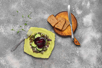 Plate with tasty vegetable salad and slices of bread on grunge background