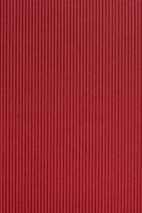 close-up of warm red color craft paper surface texture, wavy decorative and striped cardboard for greeting card for christmas, new year or valentines day, abstract background, copy space in vertical