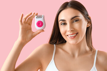 Young woman with electric epilator on pink background