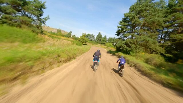FPV of riders on a motocross track. Aerial high-speed.