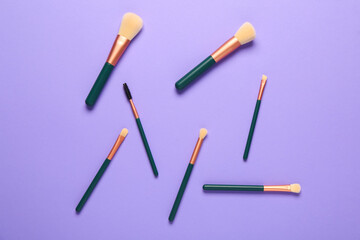 Fototapeta na wymiar Makeup brushes on purple background
