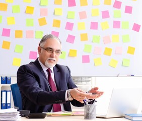 Aged man employee in conflicting priorities concept