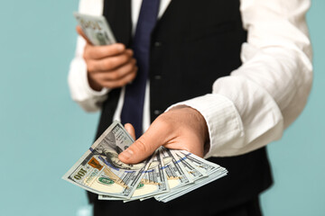 Young businessman with bribe on blue background, closeup