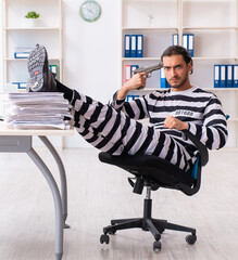 Young employee feeling like prisoner at work