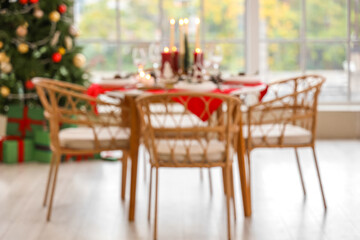 Blurred view of festive dining table with Christmas setting in room