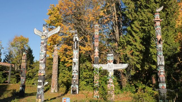 Pan left to right along the famous First Nations Totem Poles in Stanley Park during a fall season in Vancouver, British Columbia, Canada