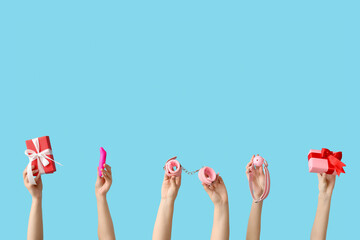 Female hands with sex toys and Christmas gifts on color background