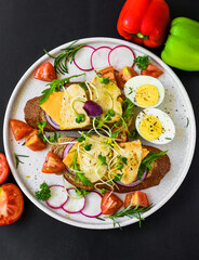  toast with chicken breast, onion and vegetables on a white plate close up