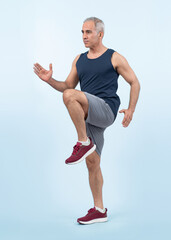 Active and fit physique senior man in sportswear portrait in running posture isolated background....