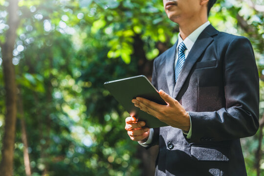 Business man using tablet to analyze Renewable energy generation is essential for the future. Renewable energy-based green business can limit climate change and global warming.