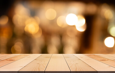 Empty wooden table top with lights bokeh on blur restaurant background.	
