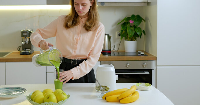 Teen girl making a spinach and banana smoothie on kitchen