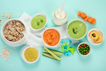 Bowls with different healthy baby food.