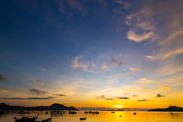 Amazing sunset or sunrise sky over sea landscape,Beautiful colorful light of nature with boats in...