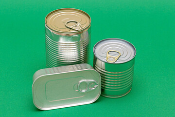 A Group of Stacked Tin Cans with Blank Edges on Green Background. Canned Food. Different Aluminum...