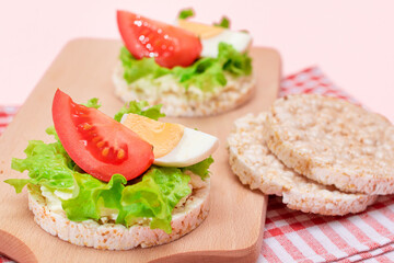 Rice Cake Sandwiches with Tomato, Lettuce and Egg on Wooden Cutting Board. Easy Breakfast. Diet Food. Quick and Healthy Sandwiches. Crispbread with Tasty Filling. Healthy Dietary Snack