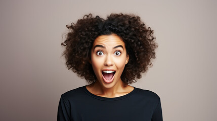 Funny surprised woman with a goofy face wearing black t-shirt isolated on brown background