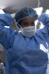 African american female doctor wearing face mask in hospital operating room