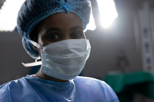 Portrait Of African American Female Doctor Wearing Face Mask In Hospital Operating Room