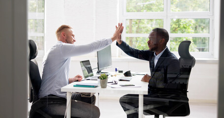 Two Smiling Young Businessmen Giving High Five