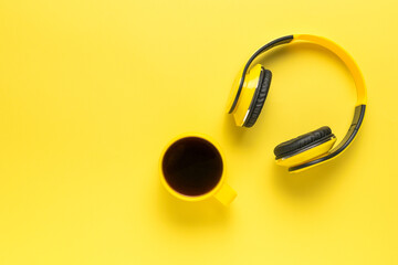 Monochrome image of headphones and a cup of coffee in yellow.
