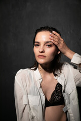 Portrait of a beautiful woman in a white shirt and black bra
