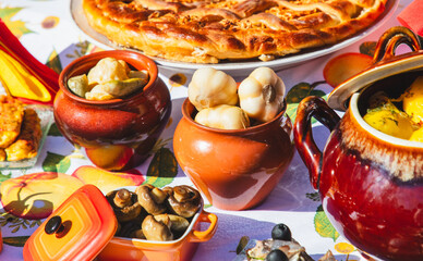 Pickled garlic in a pot on the table with other dishes