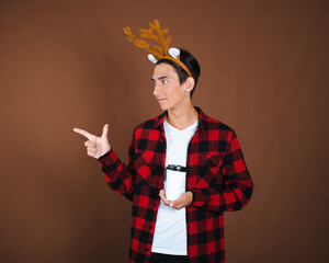 Christmas and New Year. A young attractive guy waiting for the holidays. Brown background.