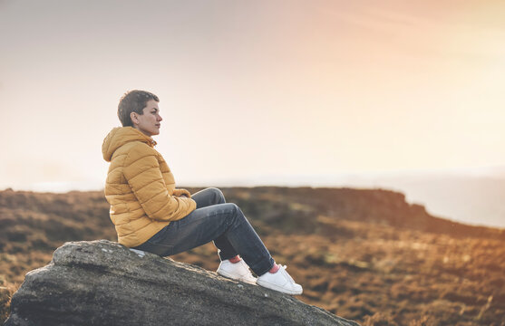 woman hiking in mountain to take timelaps of sunrise, exercise and fitness for wellness, healthy lifestyle and smile. senior mature gentleman sitting on rock, enjoing calm day toned image