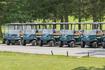 Row of Club green golf carts, with no people.  Taken at a country club.