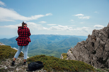 Fototapeta premium Tourist traveler on top of mountain looking at landscape