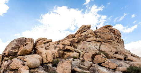 someone climbing some rocky boulders at Joshua tree national park
