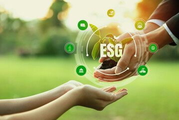Businessman and little kid holding seedling plant together with ESG and eco icon. Green business...