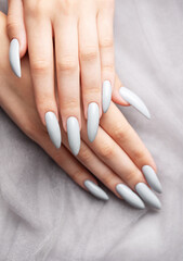 Grey nails on grey lace background.