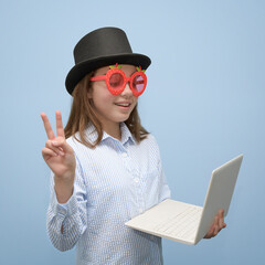 A young girl with a small white laptop in a carnival look. Party online. portrait. Square