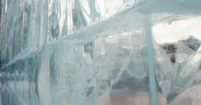 Close-up of transparent ice wall made of frozen water blocks, abstract background
