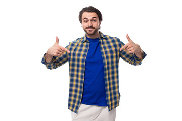 Naklejka premium smart brunette macho man with a beard and mustache in a blue shirt on a white background with copy space