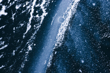 Frozen river and wave covered with ice and snow abstract winter background, effect of space and galaxy