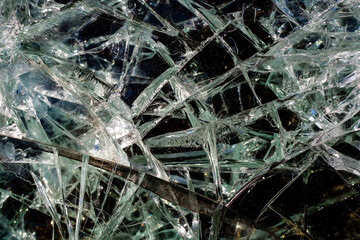 Cracks from a bullet shot in armored glass in combat vehicle. Armor piercing glass of damaged...