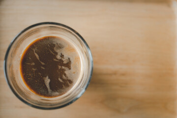 Hot mocha coffee in a small glass shot on wood table. Top view