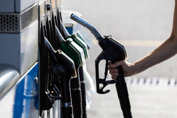 Caucasian Woman Hand Grabbing Gas Station Gasoline Black Color Pistol to Refuel her Car - Slovenia...