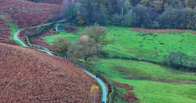 Rydal waters footpath and nature lovers walking on the lakeside on a beautiful autumn day. 