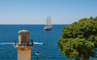 A lighthouse on the coast of Rovinj old town in Istria, Croatia, with a tall ship in the...