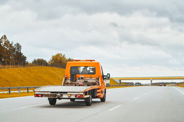 Tow truck with a broken car on a road. Tow truck transporting car on the highway. Car service...